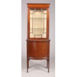 An Edwardian mahogany display cabinet of slender proportions. Astragal glazed, raised on a bow front