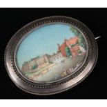 A 19th century Anglo Indian white metal brooch, framing a miniature painting depicting a river
