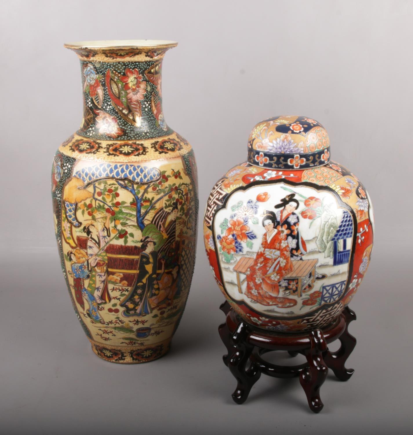 A large decorative oriental baluster shape vase, along with a ginger jar on wooden stand. Vase