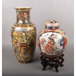 A large decorative oriental baluster shape vase, along with a ginger jar on wooden stand. Vase