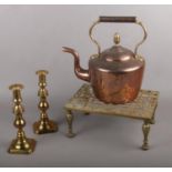 A vintage Copper kettle, brass trivet stand and brass candlesticks.