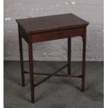A George V mahogany fold over single drawer card table. Raised on carved square supports and with