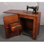 A Singer treadle sewing machine in oak cabinet.