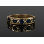A gold, diamond and sapphire ring. Set with five sapphires interspersed with four pairs of diamonds.