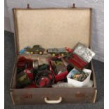 A vintage suitcase with a quantity of green and red meccano pieces & automobile accessories.