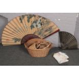 A collection of baskets, two large decorative Oriental fans including one painted in watercolour,