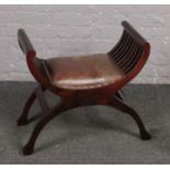 An x-frame mahogany stool with padded leather seat.