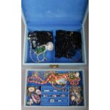 A jewellery case and costume jewellery including white paste rings, coral beads and jet etc.