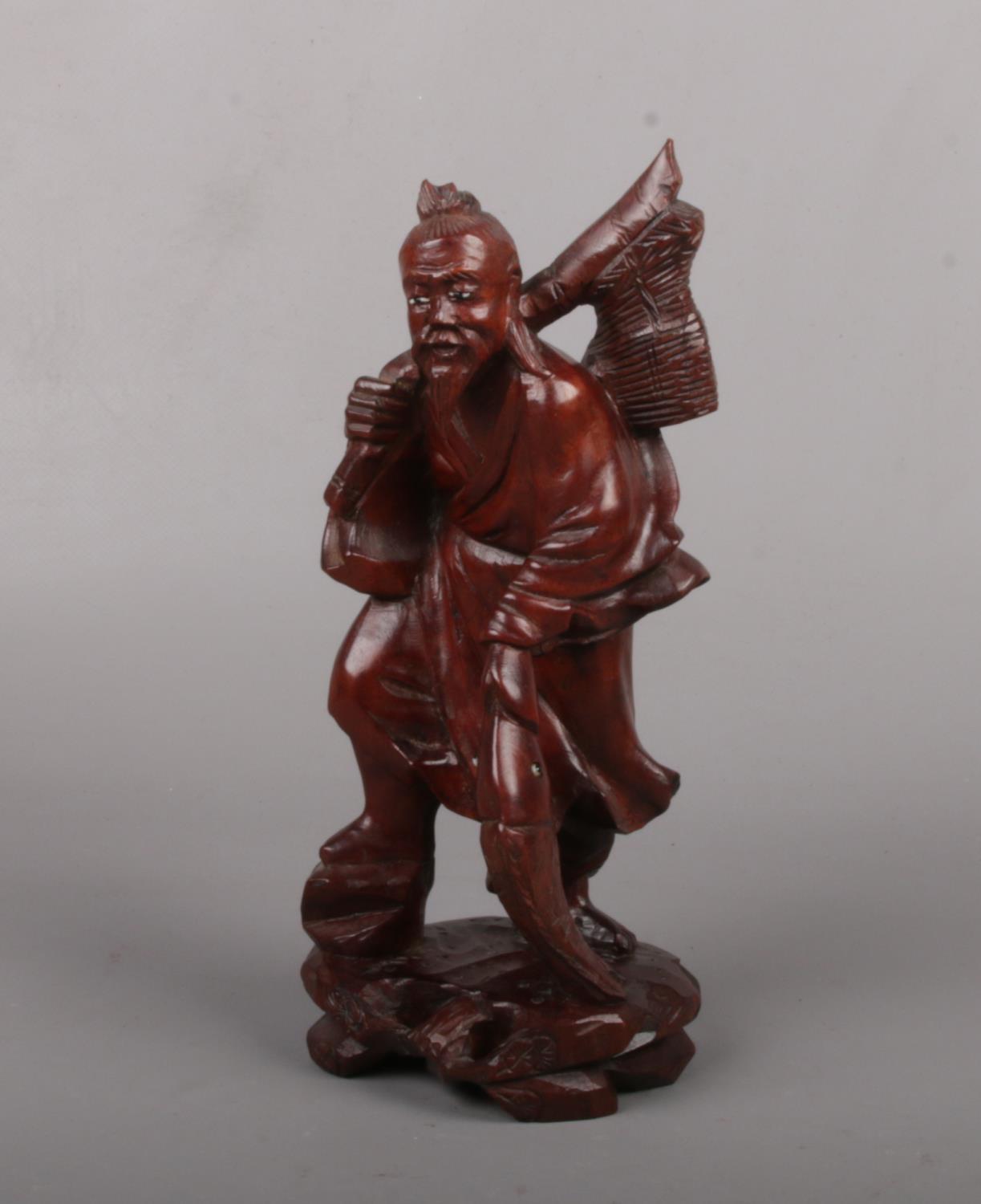 A Chinese carved hardwood figure of a fisherman with glass inset eyes, 20cm. Good condition.