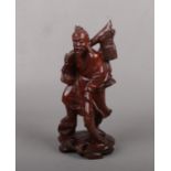 A Chinese carved hardwood figure of a fisherman with glass inset eyes, 20cm. Good condition.