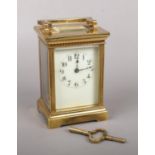 A brass cased carriage clock. With enamel dial and fluted pilasters. Backplate stamped with a