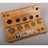 A cased set of graduated jewellers weights and tweezers. Maker A. H. Baird, Edinburgh.