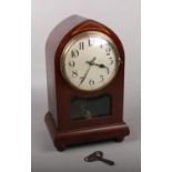 A mahogany cased lancet torsion clock. With silvered dial having Arabic numeral markers, 31cm