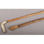 Two walking sticks with antler toppers, one inset with silver assayed Sheffield 1917. The sticks are