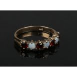 A small 9ct gold opal and garnet dress ring. Size I 1/2.