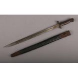 A sword bayonet in leather scabbard. Unmarked, blade length 43.5cm. HEavy pitting. Scabbard in tired