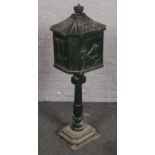 A painted cast iron post box on pedestal stand with horse racing decoration. Provenance, Lathom