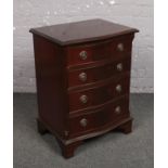 A small mahogany serpentine chest of drawers.