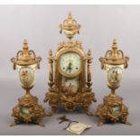 A decorative brass mounted clock garniture, decorated with scenes of courting couples.