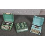 Two cased vintage typewriters and a Sumlock.