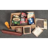 A box of miscellaneous household items including boxed Olympus digital camera, photograph frames and