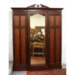 A late Victorian mahogany triple mirror front wardrobe. With panelled doors and triangular pediment,