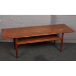 A teak two tier coffee table, 150cm x 50 cm.