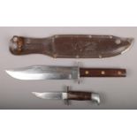A Bowie knife in leather scabbard. Blade stamped Whitby and Original Bowie Knife, having clipped