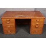 A light oak knee hole desk with filing drawers.