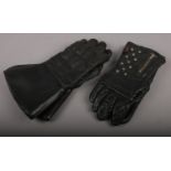A pair of leather motorcycle gauntlets, along with a pair of motorcycle gloves.