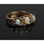 An 18ct gold, opal and diamond seven stone ring. Hallmark for Chester, no date letter. Size L.