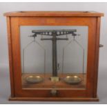 An oak cased set of Philip Harris Ltd scientific balance scales. Glass in top missing.