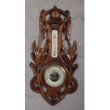 A small carved mahogany wall barometer.