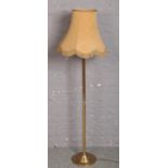 A brass standard lamp with circular base