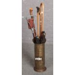 Brass umbrella stand with walking sticks and umbrella's