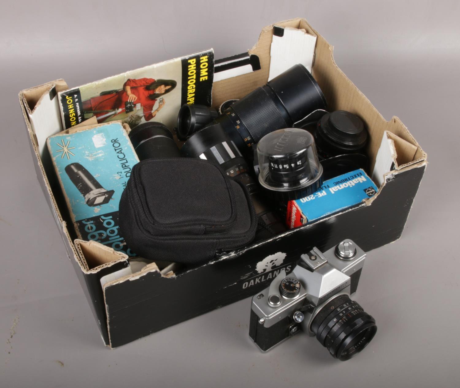 A box of camera equipment to include Praktica camera, lenses etc.