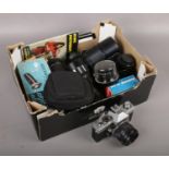 A box of camera equipment to include Praktica camera, lenses etc.