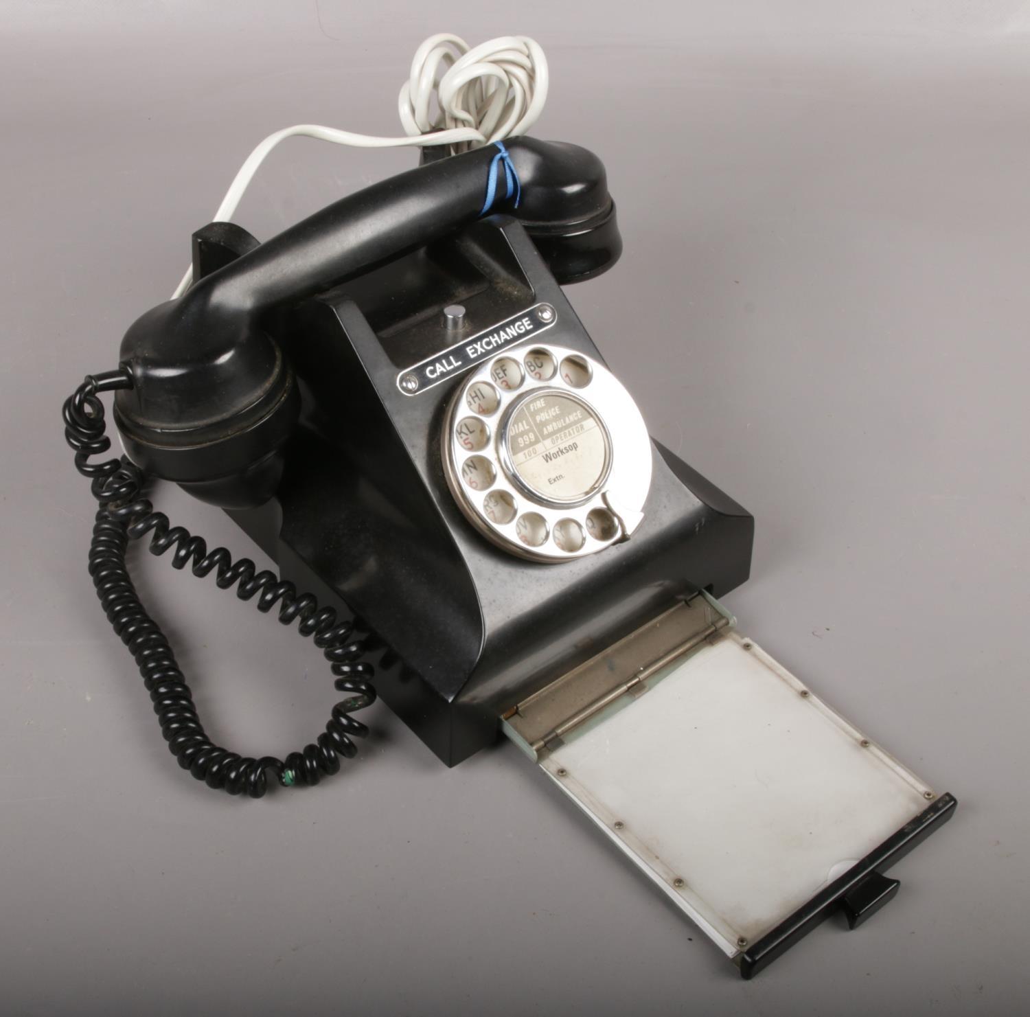 A black vintage rotary dial telephone.