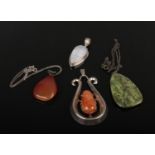 Four large hardstone silver mounted pendant, two with chains.