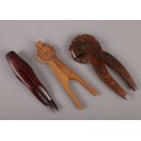 A Scandinavian chip carved treen nut cracker, another folk art wooden nut cracker and one formed