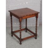A George V oak occasional table with scalloped top and raised on barley twist supports, 5cm