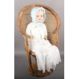 A large doll marked HW JUBILEE in Victorian dress, sat in cane work chair.