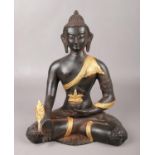 A parcel gilt cast bronze figure of a medicine Buddha. (Height 29cm).