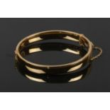 A gold plated bangle with engraved detail. Stamped 1/5 9ct, G. J. Ltd.