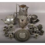 A box of pewter to include teapot, jug, serviette rings etc.