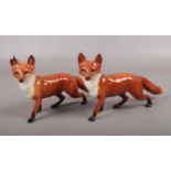 Two Beswick figures of foxes. (Height 13cm). One with chip to ear.