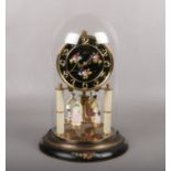 A Kern torsion clock under glass dome. The pendulum disc is surmounted by four china figures. With