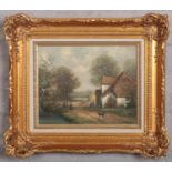 A 20th century Dutch school gilt framed oil on board. Country landscape with cottages and figures.