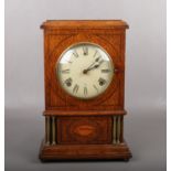 An American oak cased 8 day mantel clock. With brass column supports and marquetry shell patera.