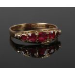A late Victorian 9ct gold ring set with red stones in a boat shaped setting. Size P.